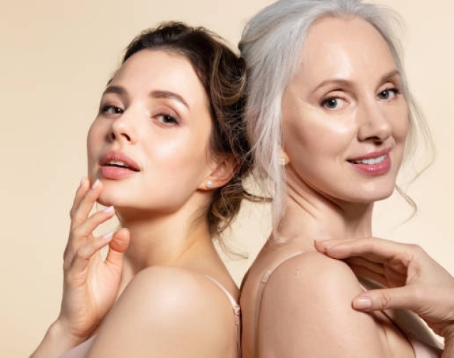 Two beautiful different age woman with perfect skin headshot portrait. Senior lady and young girl in underwear standing back-to-back posing for camera. Spa beauty salon procedure and home skincare
