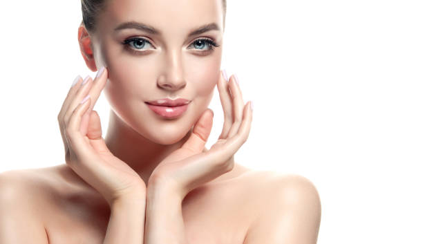 Gorgeous, young  woman is demonstrating clean fresh skin and touching  own face. Example for advertising of facial treatment, cosmetology, beauty technologies and spa.